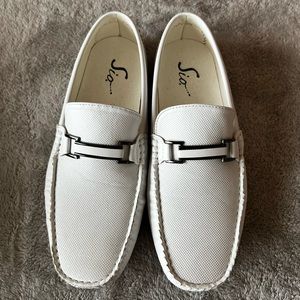 White dress slip on shoes with black grip on bottom.